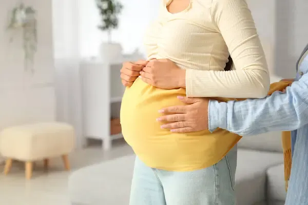 stock-photo-doula-massaging-beautiful-young-pregnant-woman-scarf-home-closeup